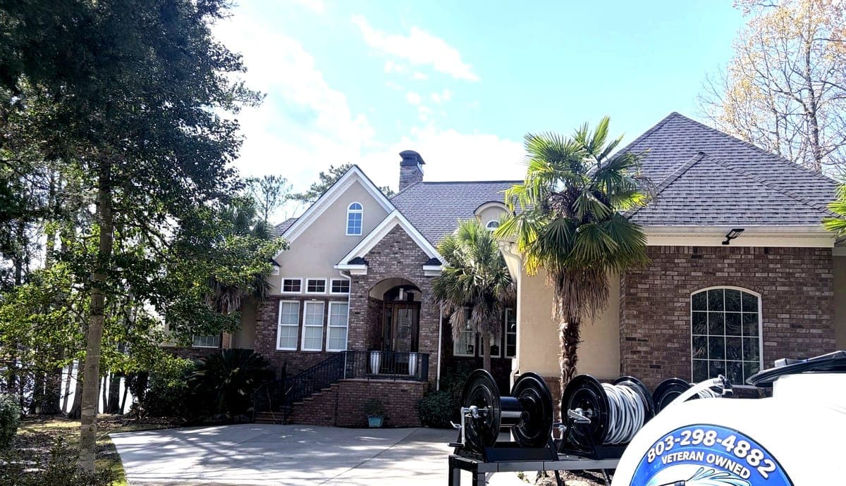 Bub's Pressure Washing trailer in front of a home during house washing service