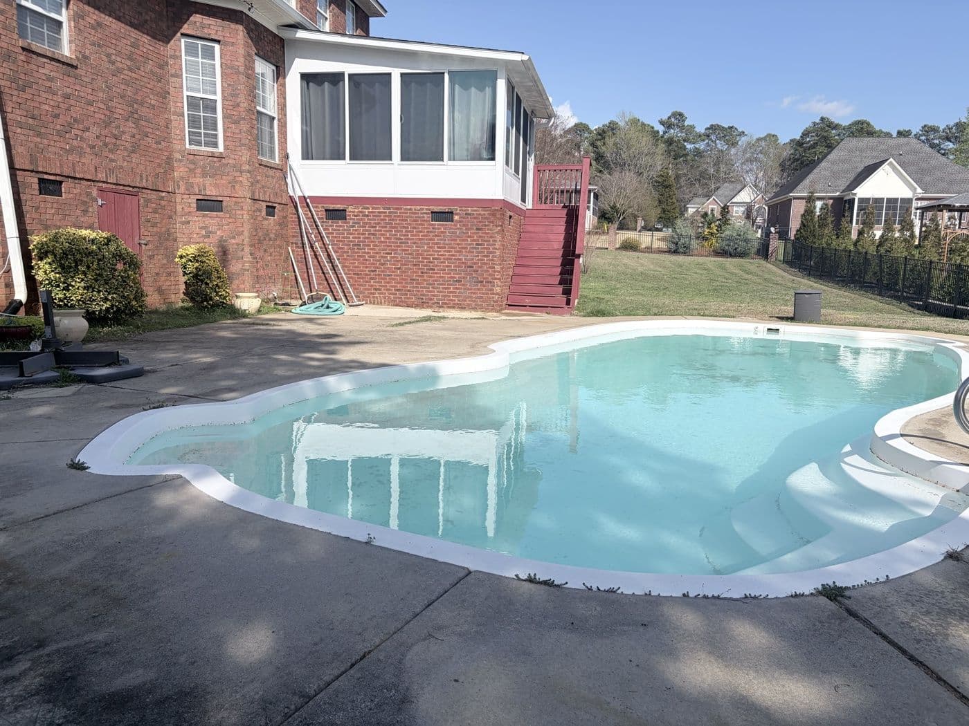Clean pool deck and surrounding concrete after professional pressure washing
